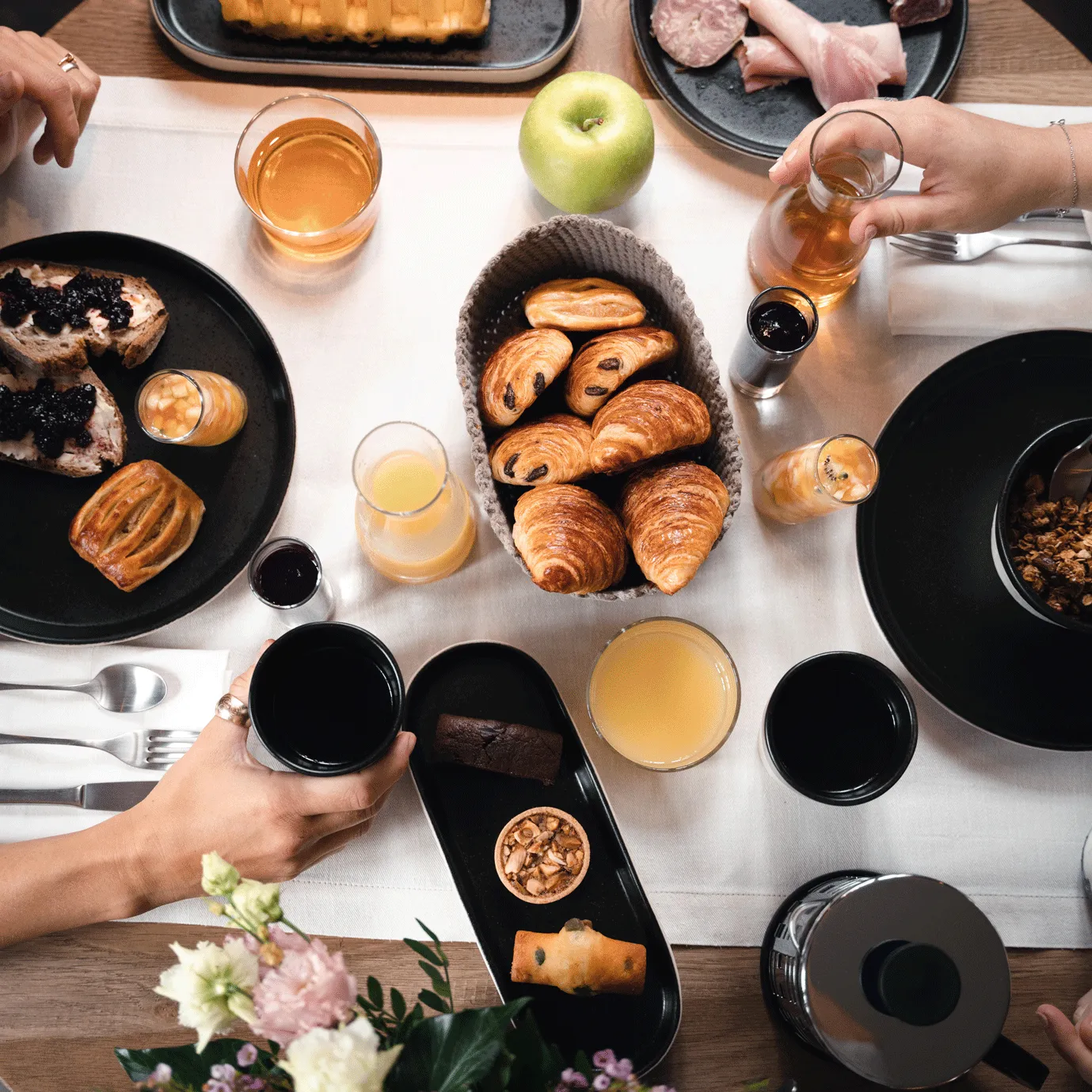 petit-déjeuner avec jus, viennoiseries, fruits et céréales