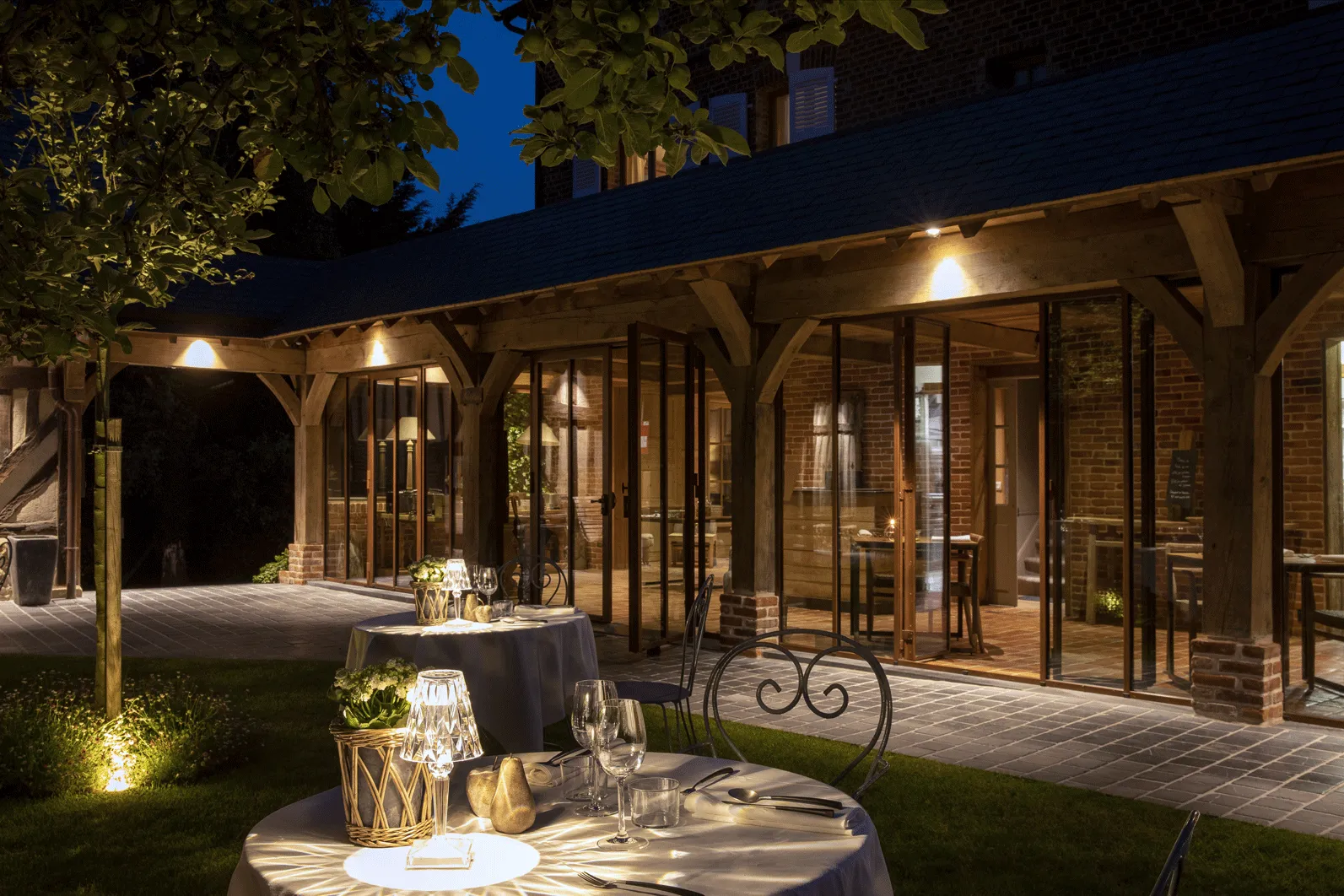 tables extérieures du restaurant de l'Auberge de la Source vue de nuit